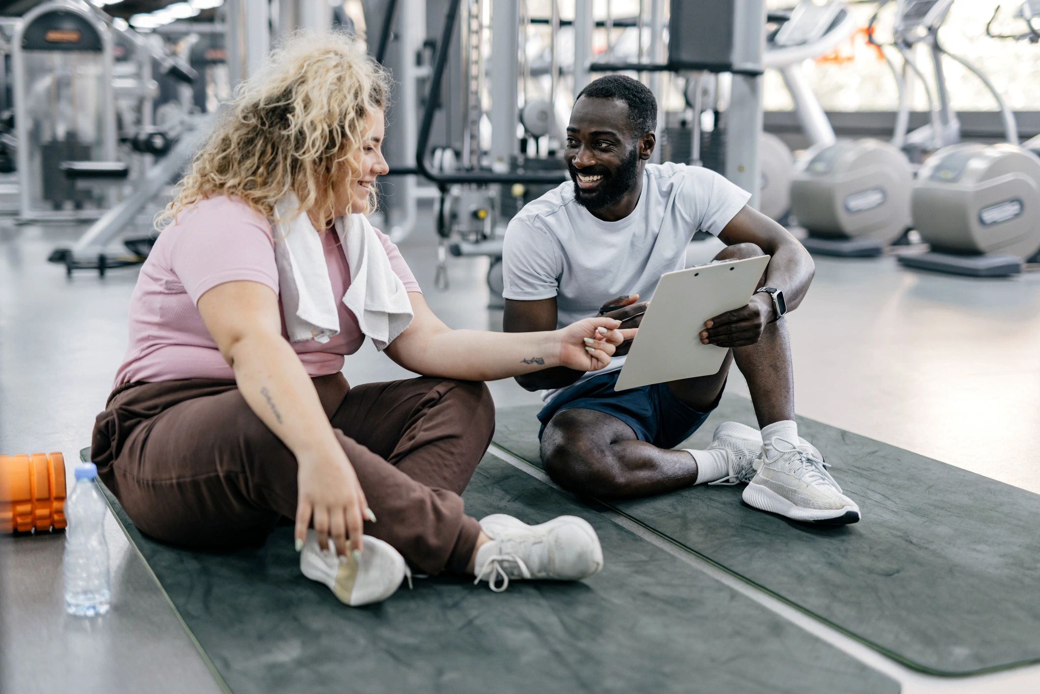 Trainer coaching a client in a gym